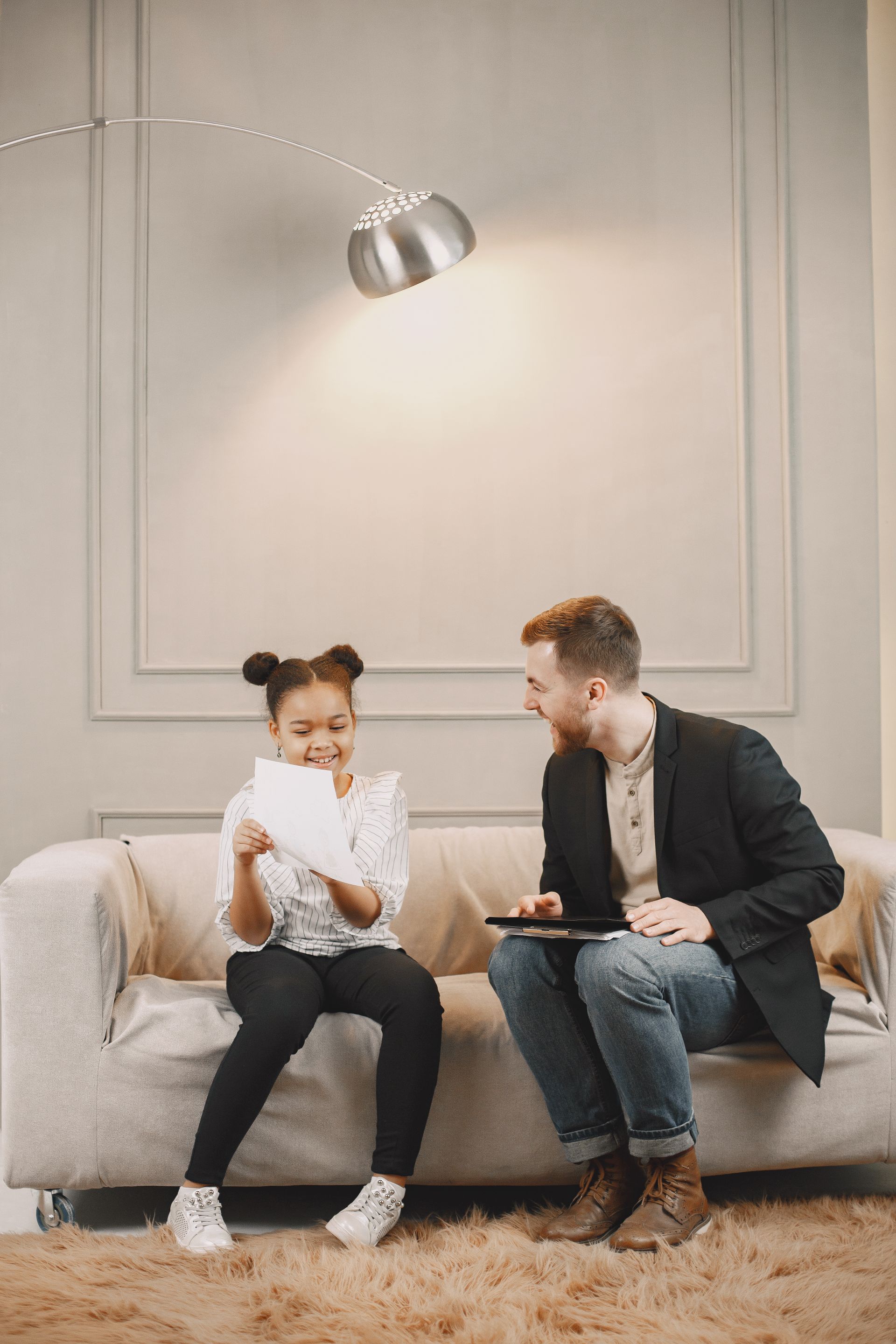 A young girl and a clinician sitting together during a family therapy session