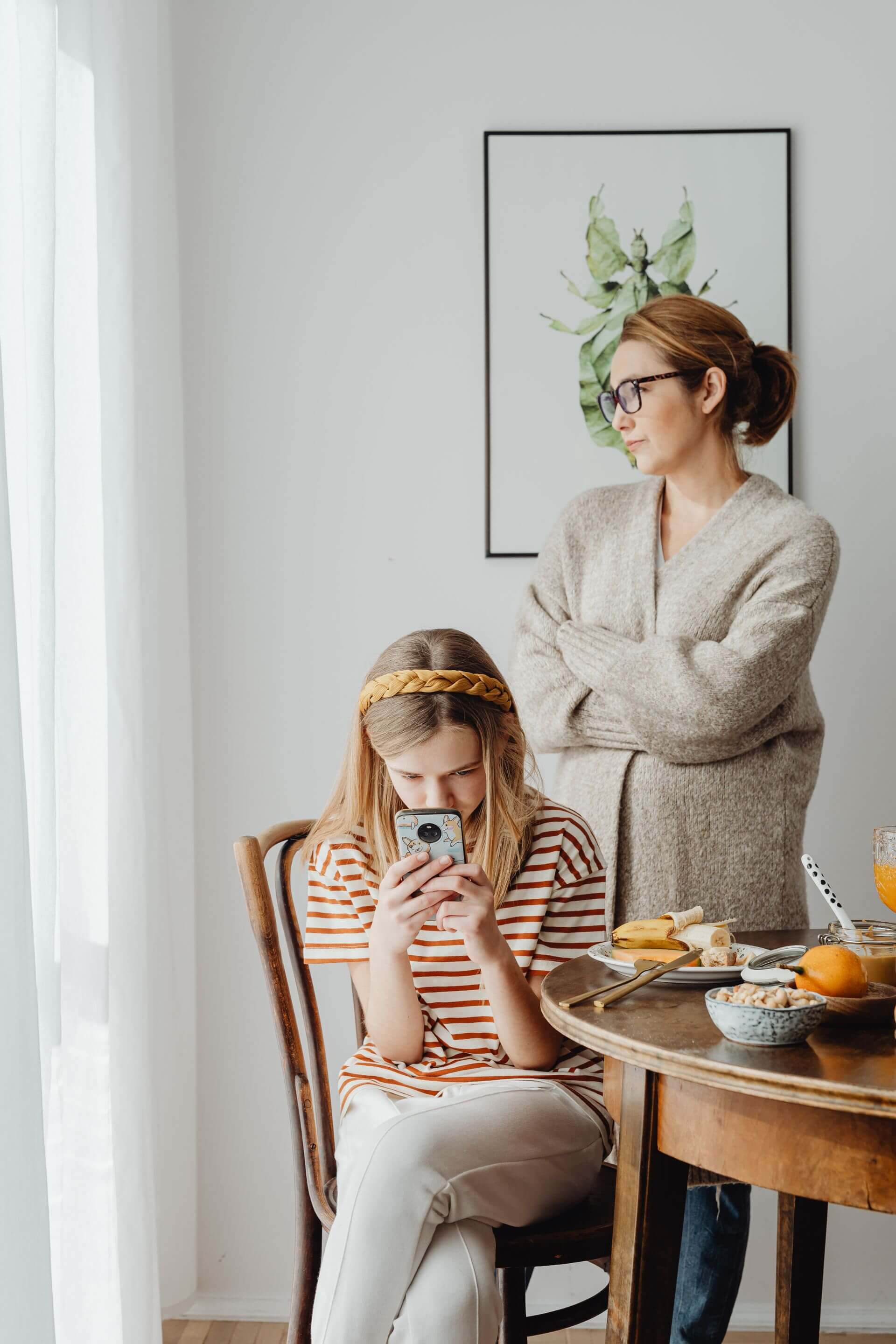 A family of four sitting together in a therapy session, talking with their clinician